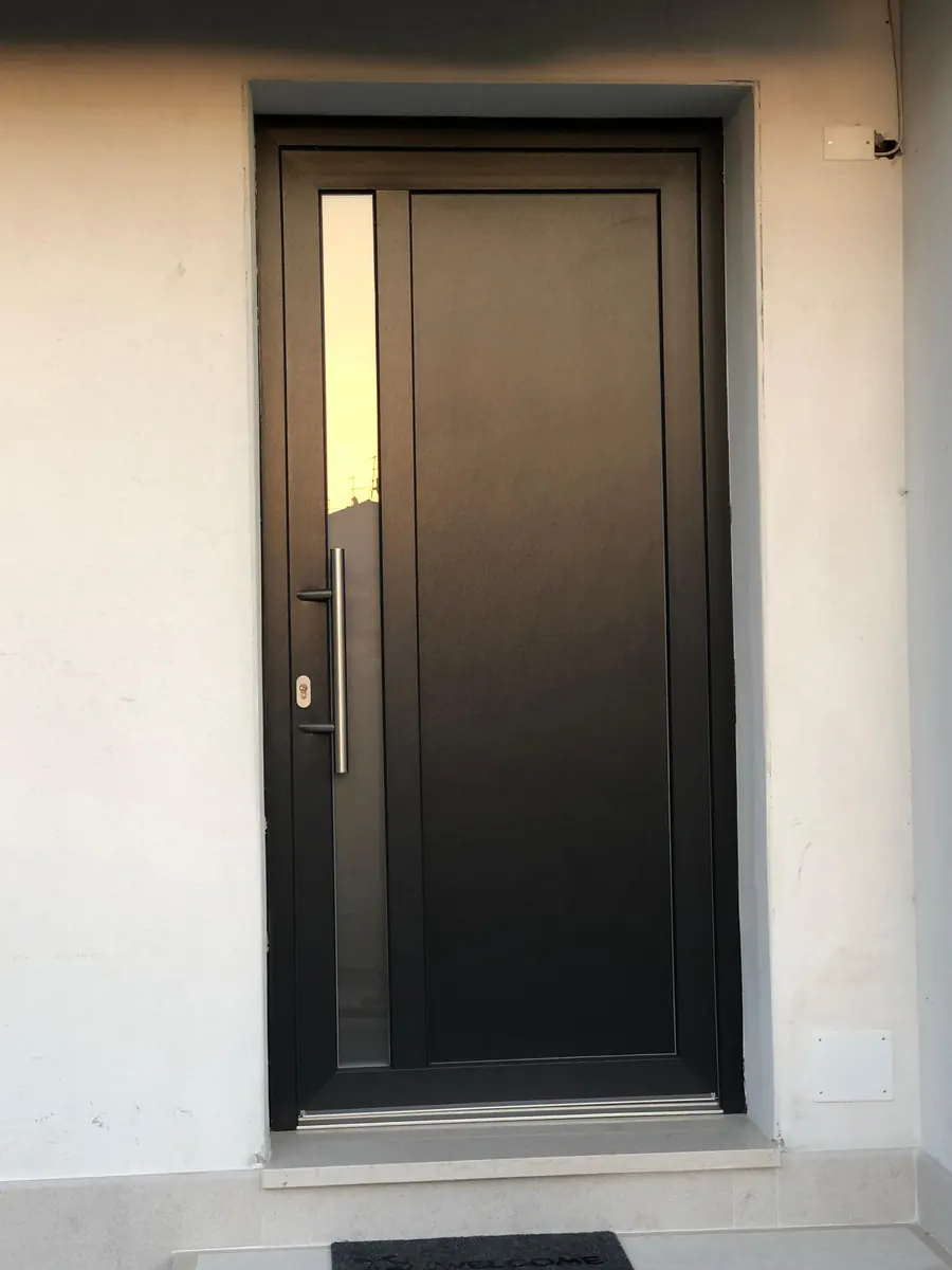 Portoncino d'ingresso scuro con vetro laterale stretto e maniglione in acciaio