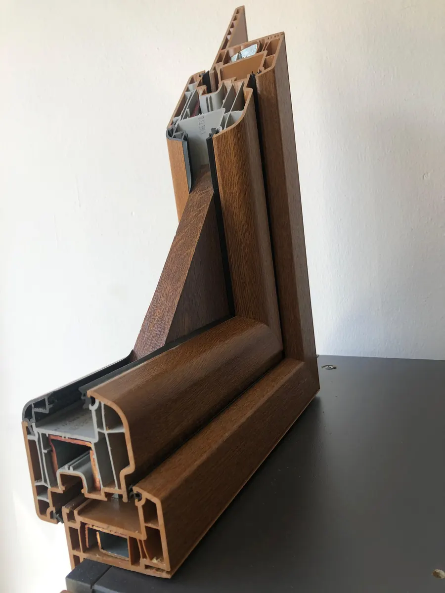 Sezione di un profilo per finestre con finitura effetto legno, si vedono le camere interne